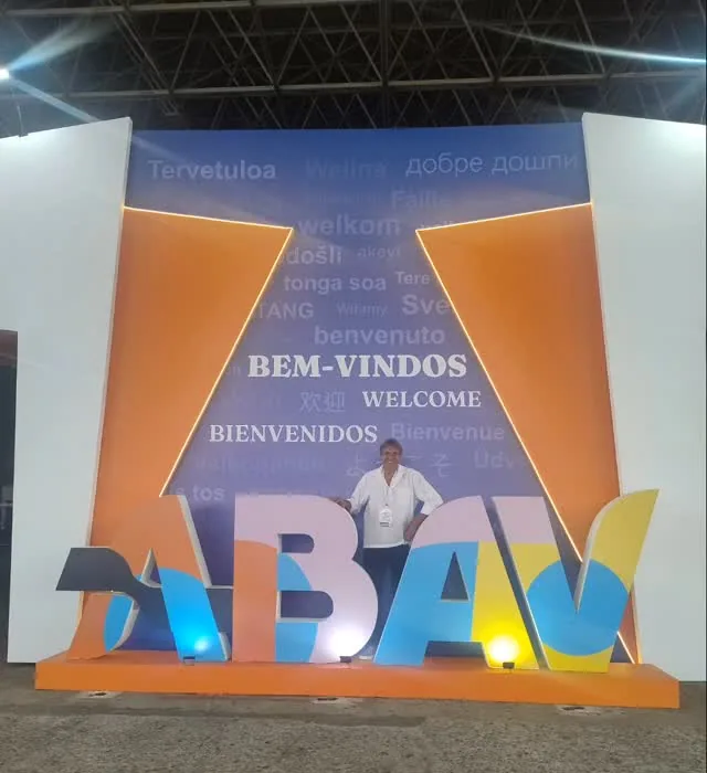 Solivam ao lado do letreiro colorido da ABAV, na feira de turismo do Rio de Janeiro.